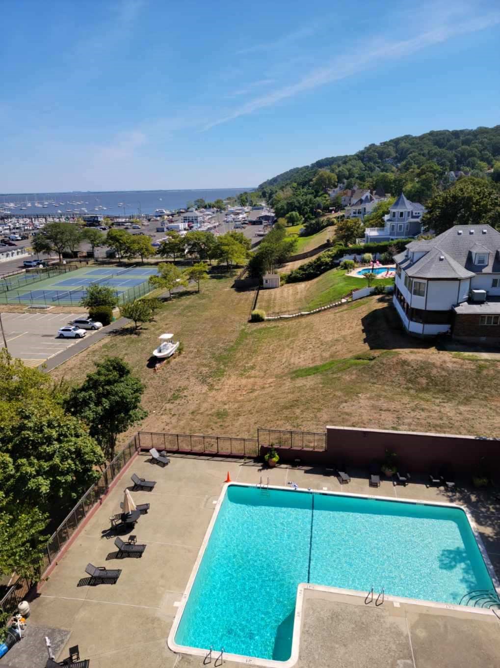 an aerial view of a pool and a house with a view of the ocean