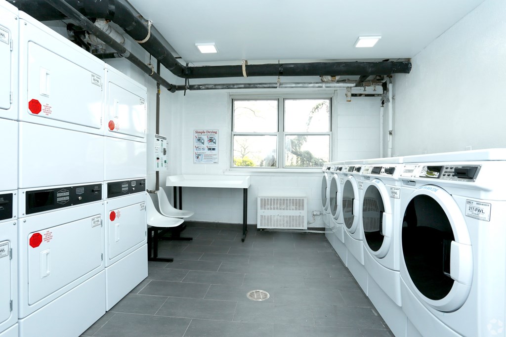 a laundry room with washers and dryers and a window