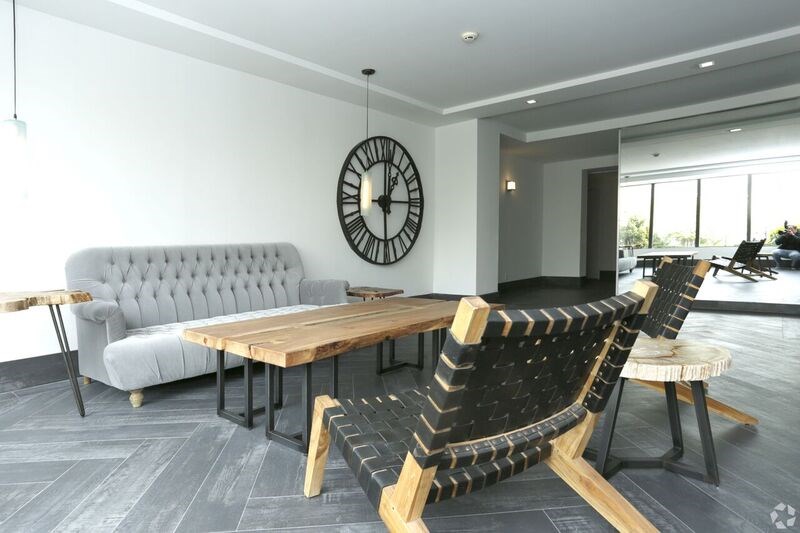 a living room with a table and chairs and a clock on the wall
