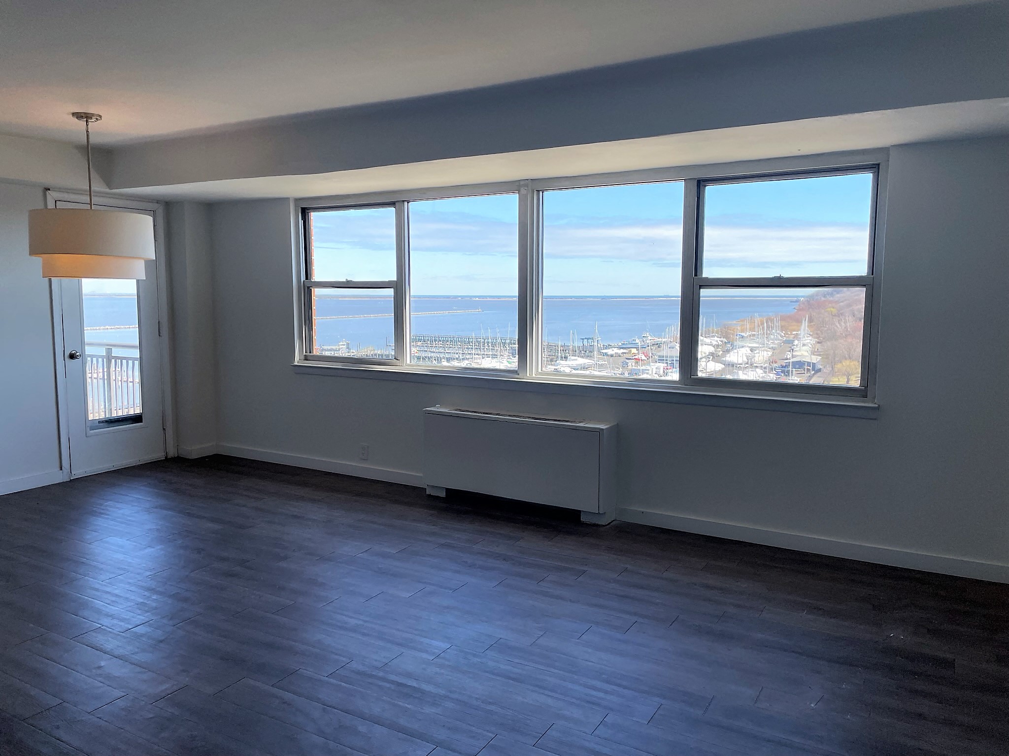 an empty living room with a view of the ocean from the window