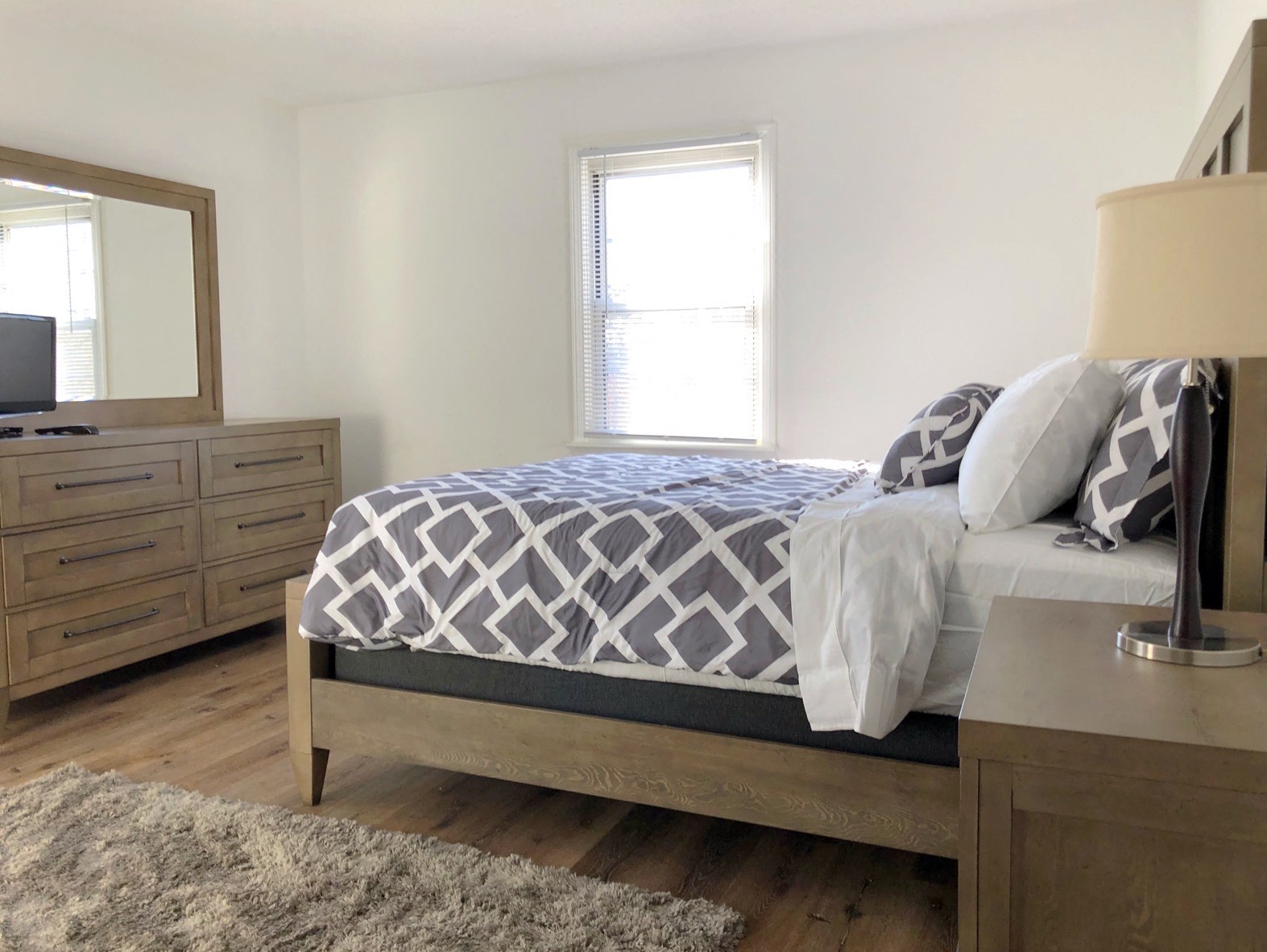 a bedroom with a bed and a dresser and a window