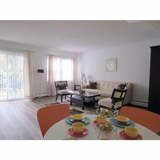 a living room and dining room with a table and chairs