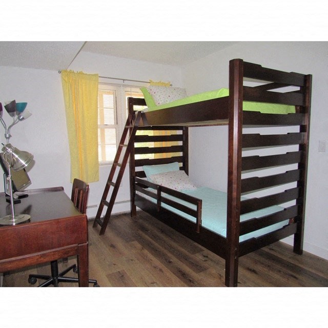a bunk bed in a small room with a desk