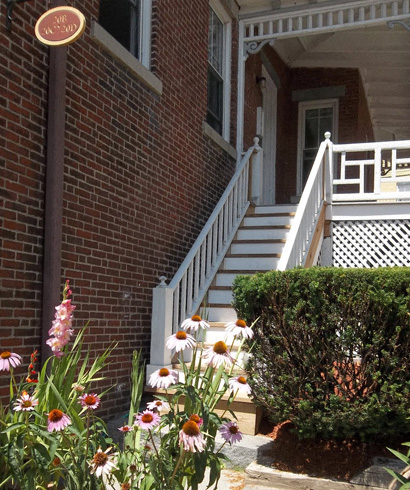 the stairs to the front porch of a brick house