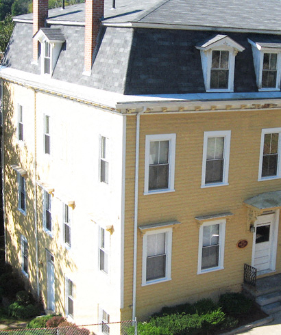 a yellow house with a roof on top of it