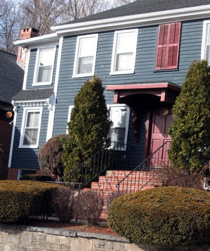 a blue house with a red door and a staircase
