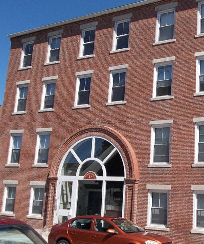 a red car parked in front of a brick building