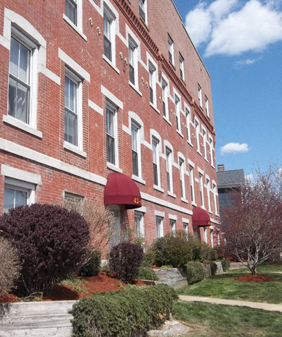 a large brick building with red awnings and a sidewalk