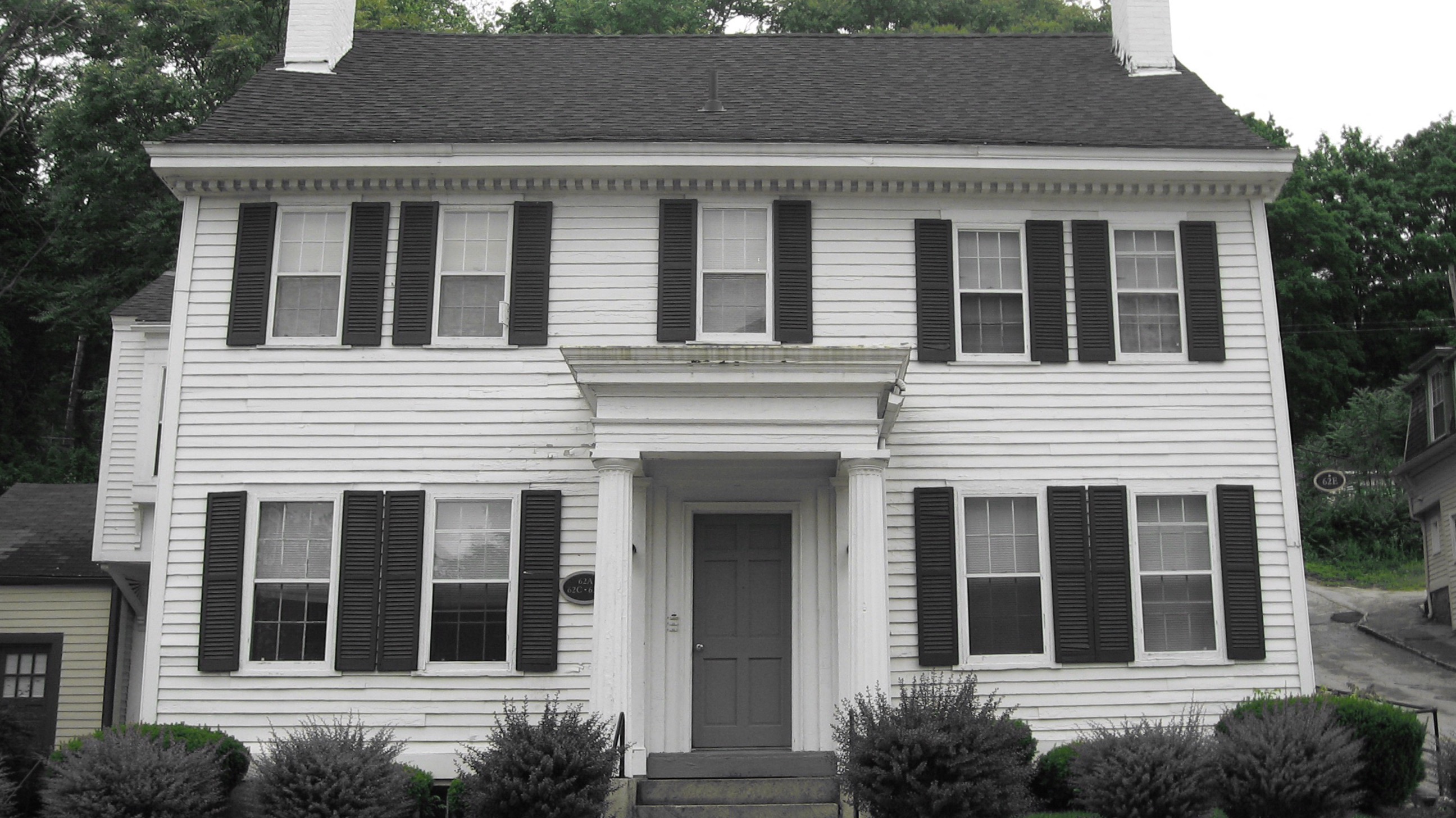 a white house with black shutters and a black door