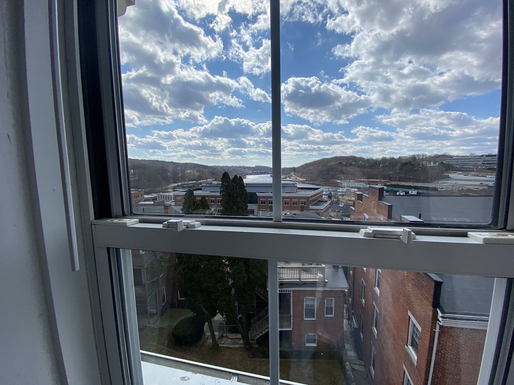 a view from a window of a city with a cloudy sky