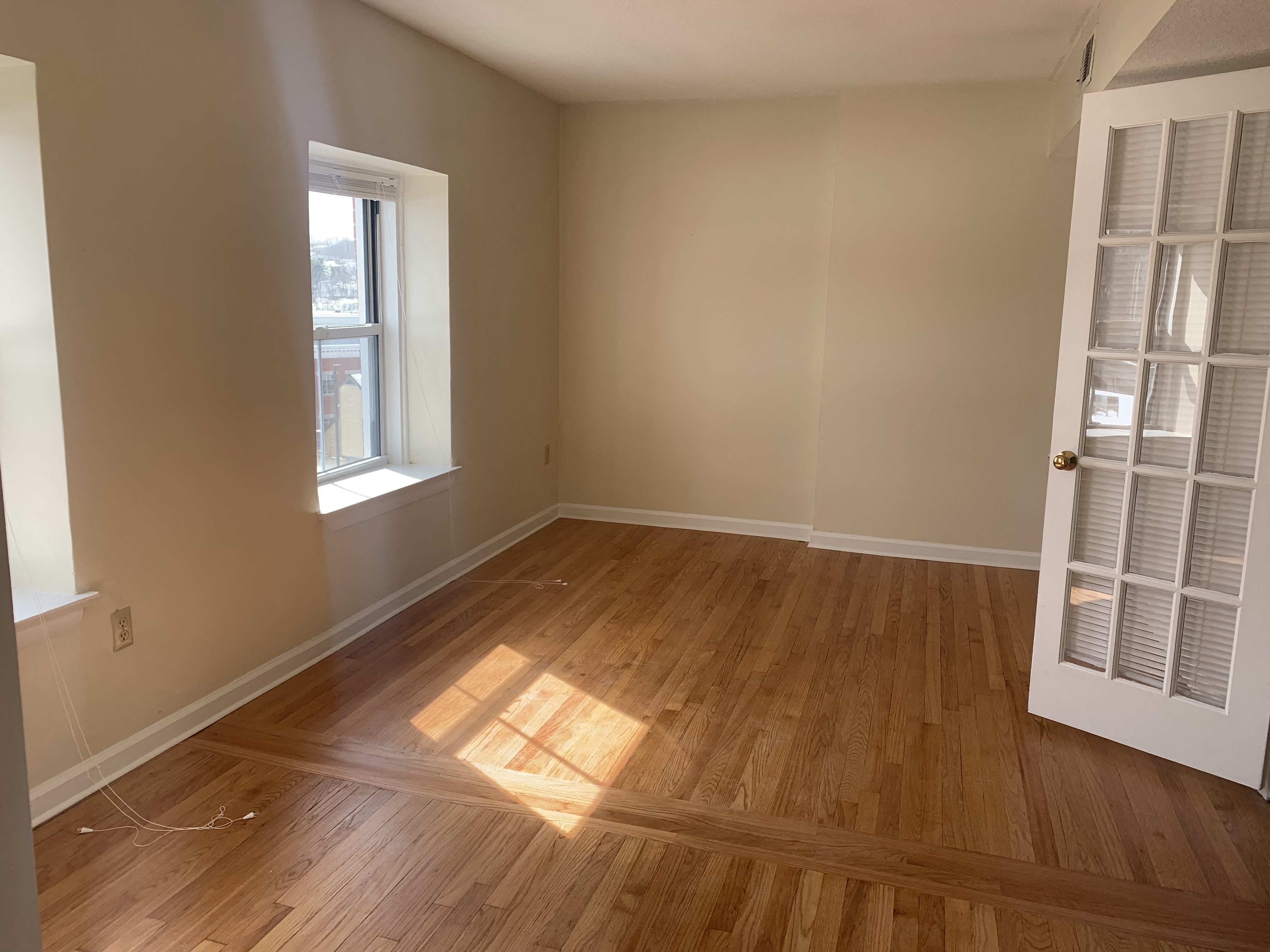 an empty room with wooden floors and a white door