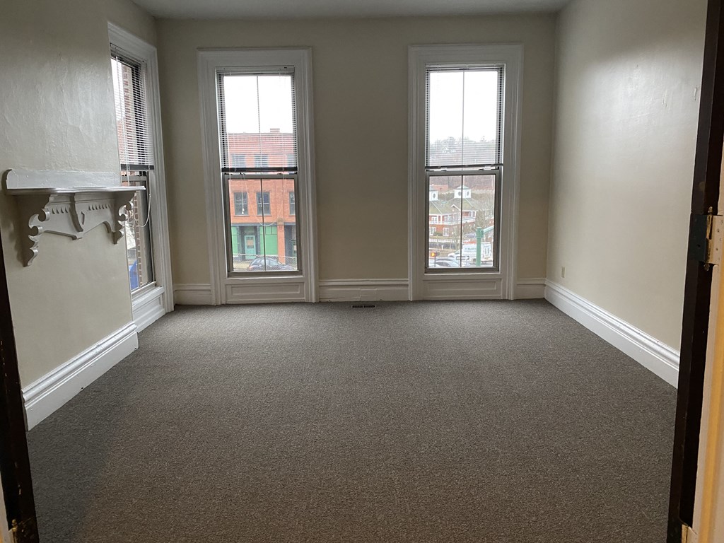 an empty living room with three windows