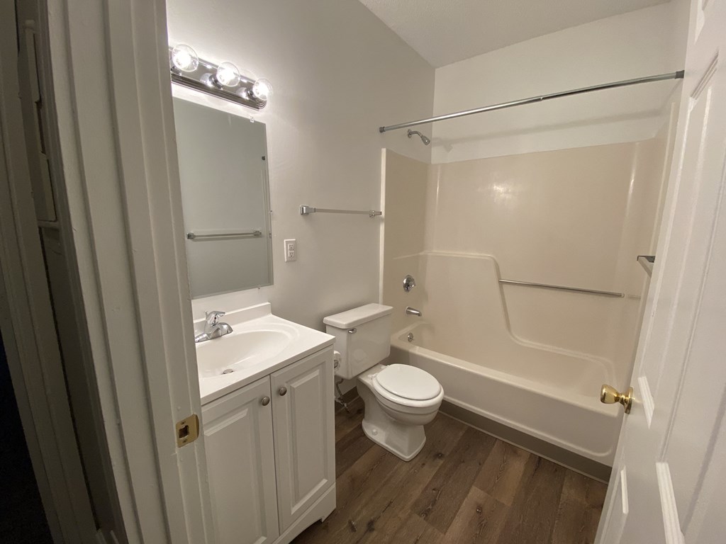 a bathroom with a toilet sink and tub and a mirror