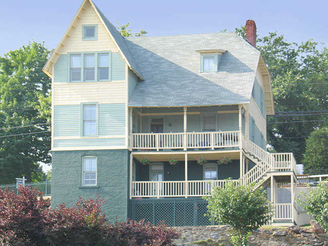 a yellow and green house with a balcony