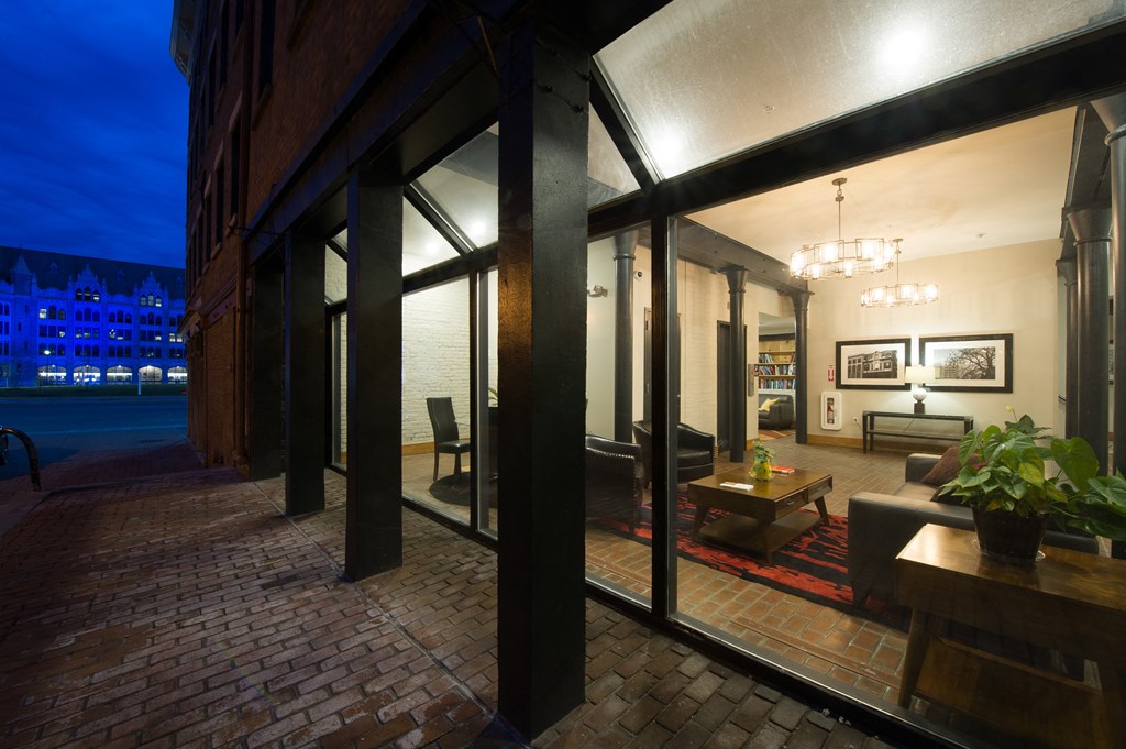 the lobby of a building at night with a view of the street