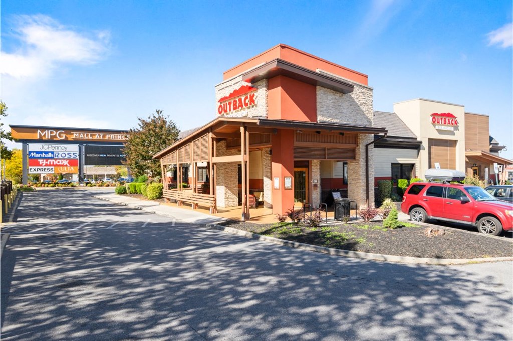 a restaurant with a red car parked in front of it