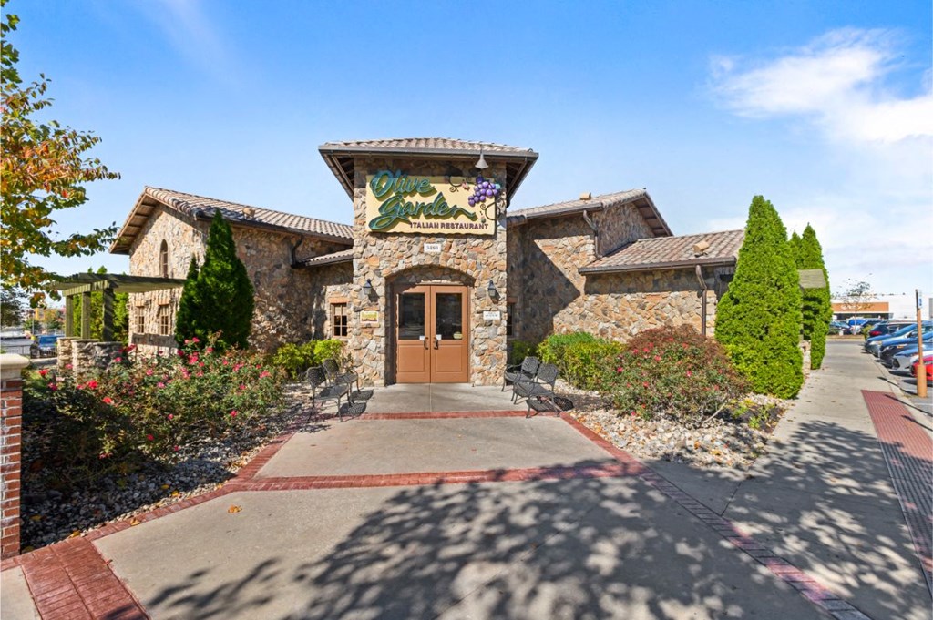 the front entrance of a stone building with a brown door and a mural on it