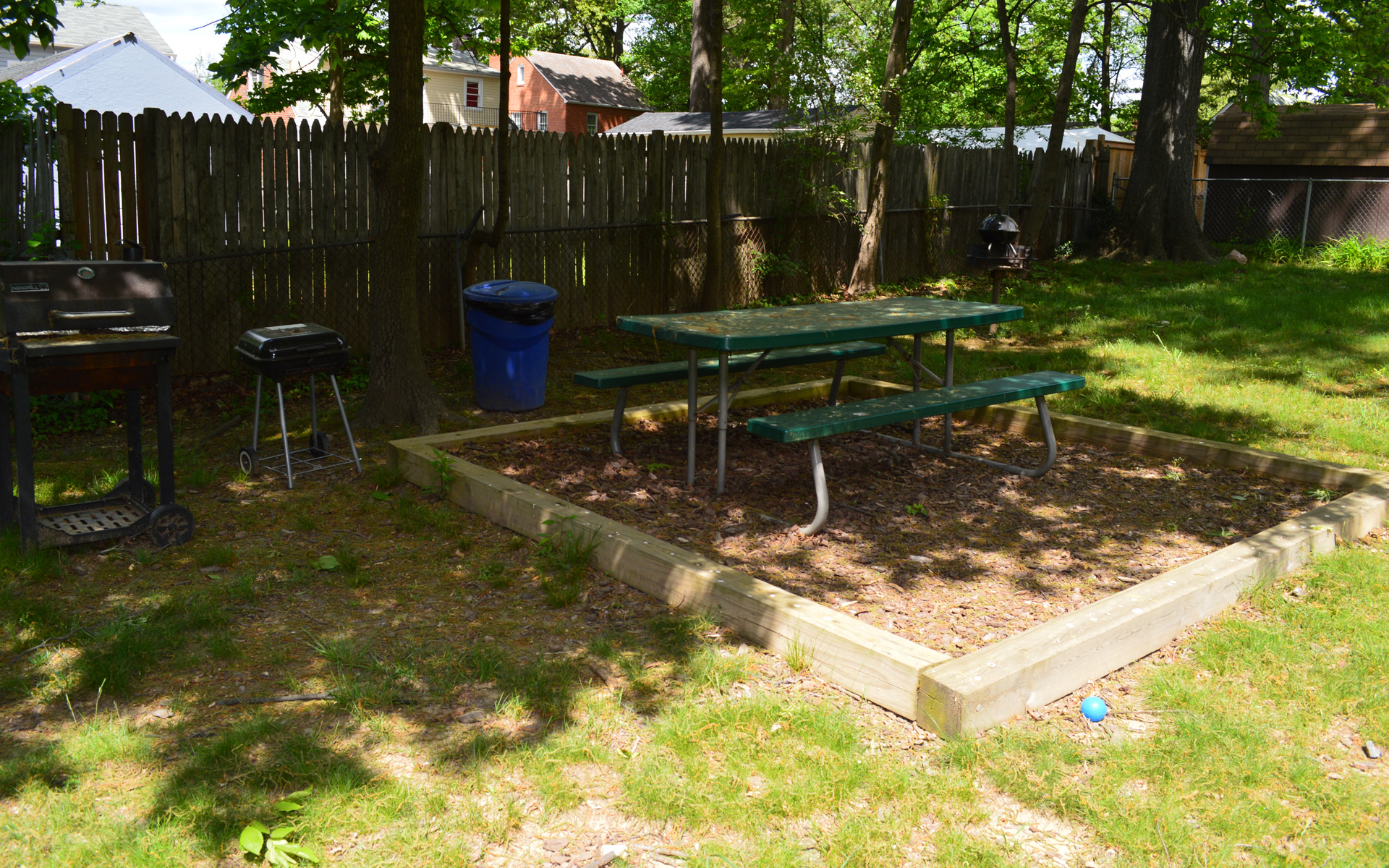 a garden with a picnic table and a bench