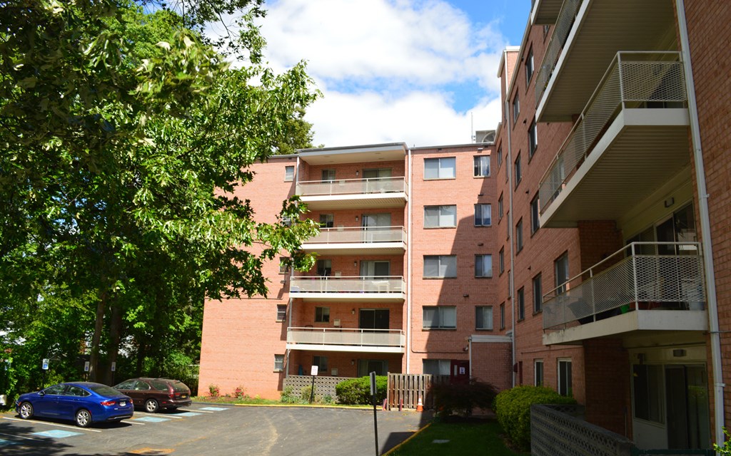 an apartment building with cars parked in a parking lot