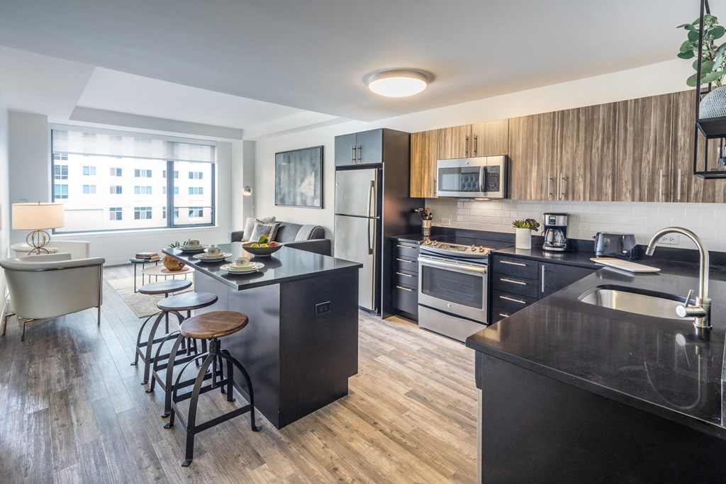 an open kitchen and living room with a large island and a dining room table