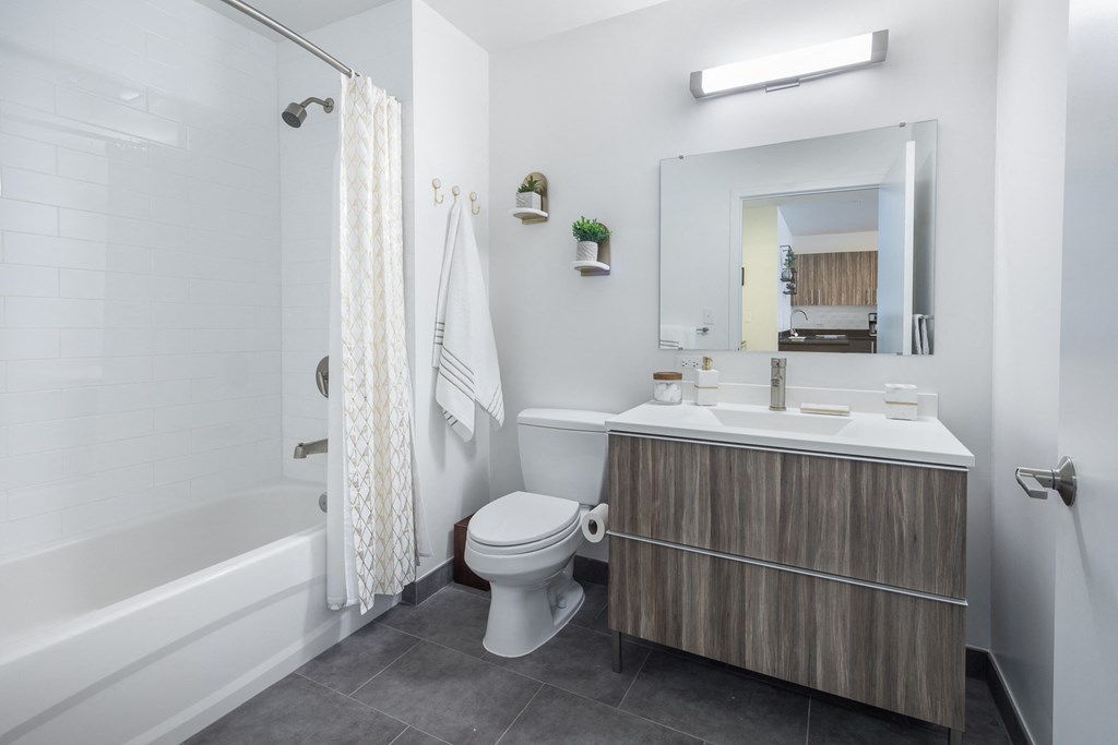 a bathroom with a toilet sink and shower and a mirror