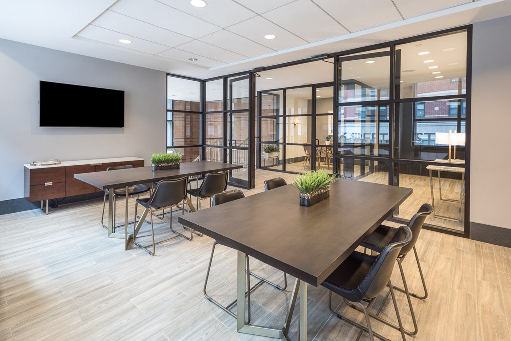 a conference room with tables and chairs and a tv