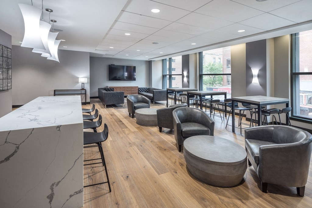a lounge area with chairs tables and chairs and a television