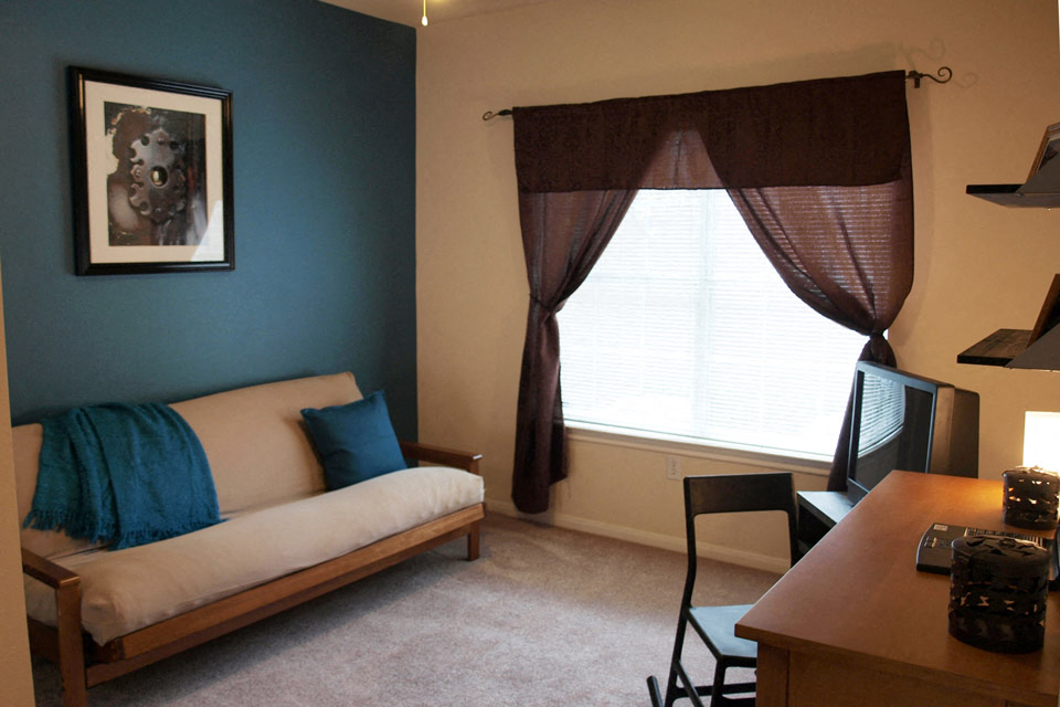 a living room with a couch and a desk