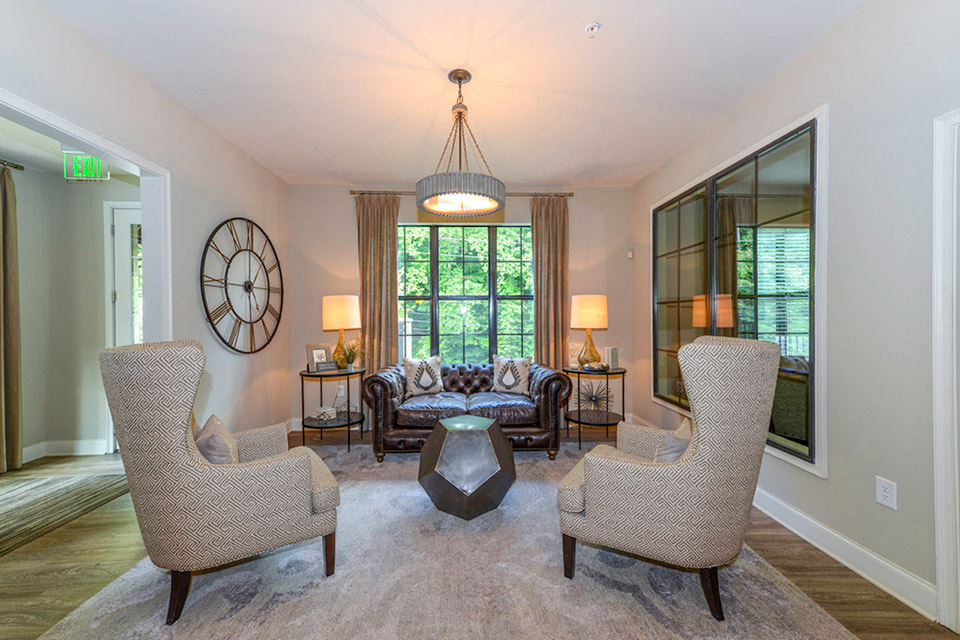 a living room with a couch and chairs and a large window