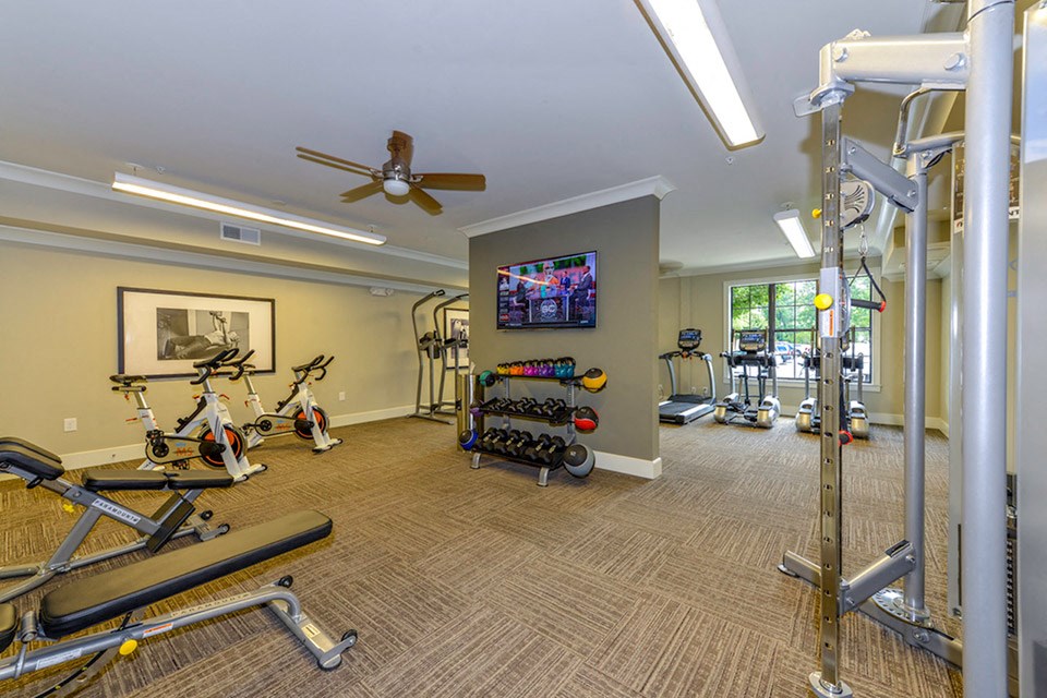 a gym with exercise equipment and a tv