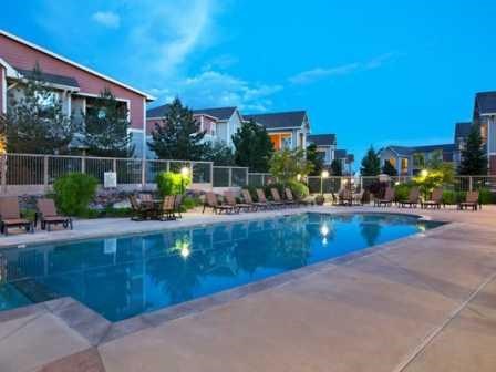 a large swimming pool with buildings in the background