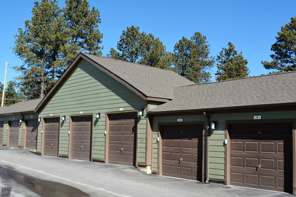 a row of garages with brown garage doors