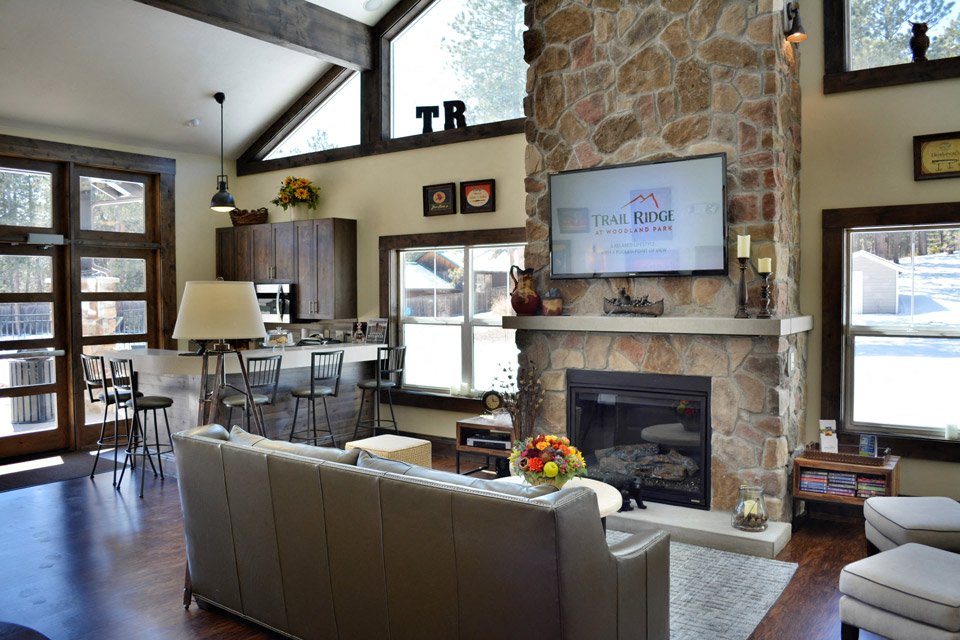 a living room with a stone fireplace and a tv above it