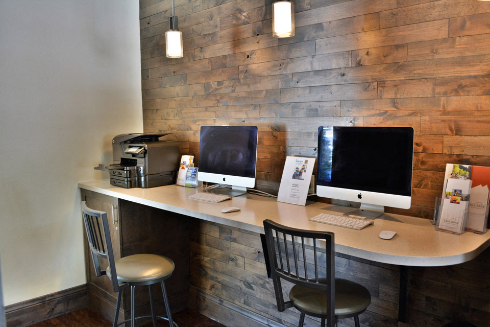 a computer desk with two monitors and two chairs