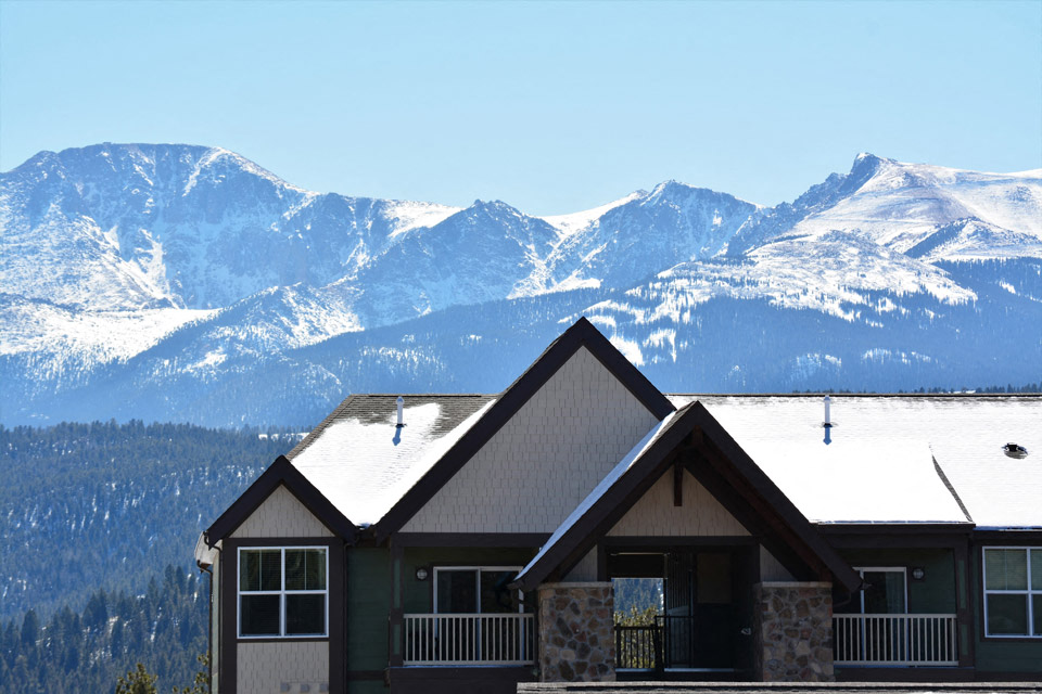 a house with snow covered mountains in the background