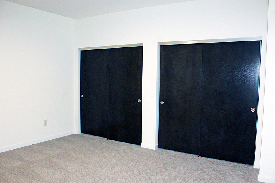 an empty room with two black doors