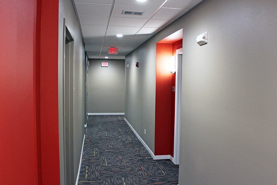 a hallway with red and gray walls and gray and red doors