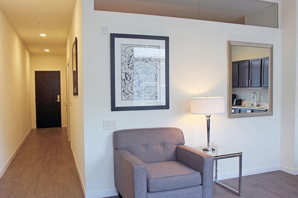 a living room with a chair and a mirror on the wall