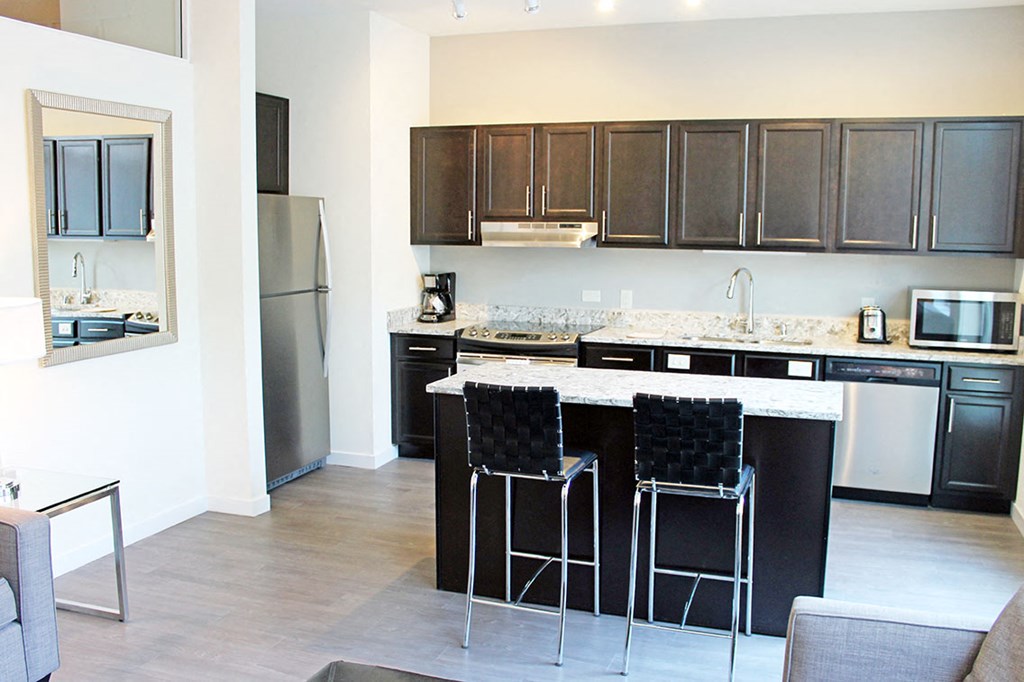 a kitchen with an island and stainless steel appliances
