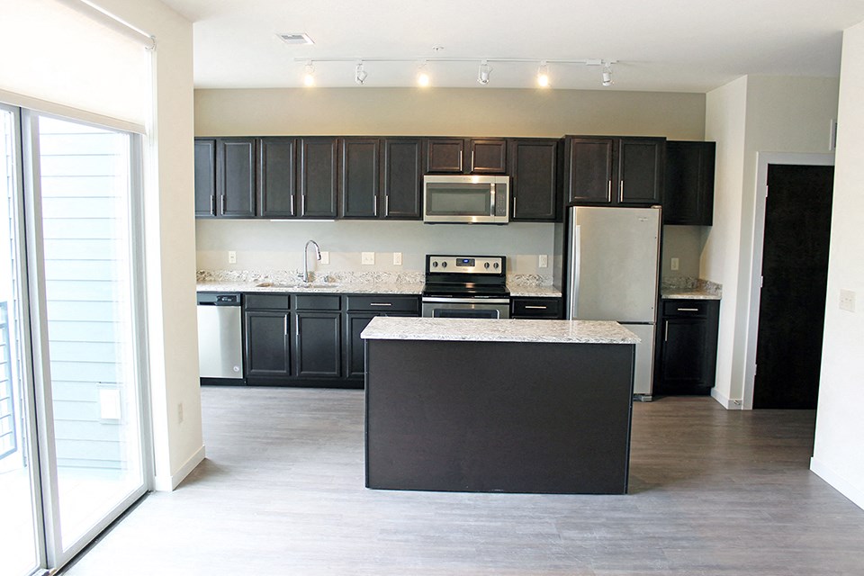 a kitchen with black cabinets and a white counter top
