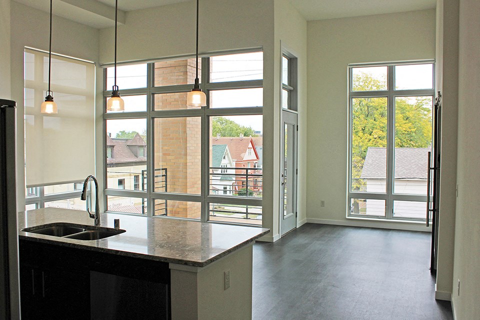 an open kitchen with large windows and a sink
