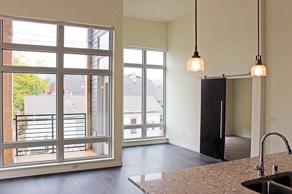 an empty kitchen with a large window and a sink