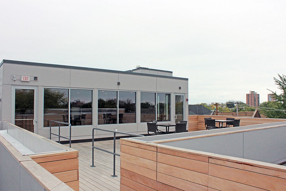 a rooftop deck with a building in the background