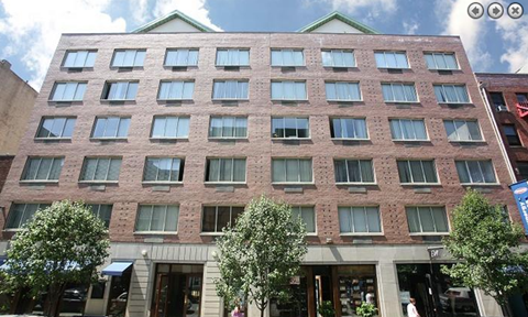 a tall brick building with trees in front of it