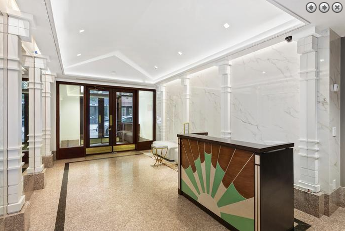 a large lobby with a reception desk and a door