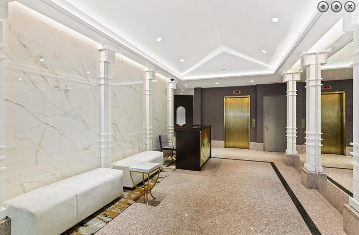 a lobby with white marble pillars and a reception desk