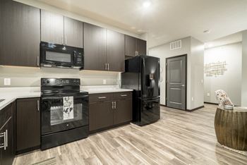 Kitchen with dark brown traditional cabinets and black appliances