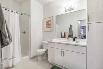 The Conrad-Contemporary design scheme bathroom with white cabinetry and countertops