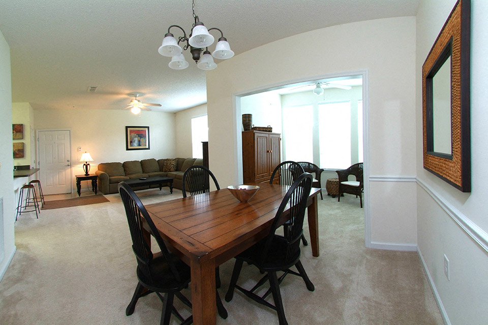 a dining room and living room with a wooden table and chairs