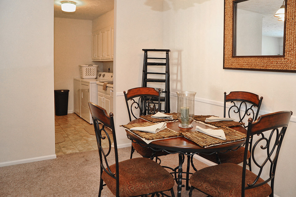a dining room with a table and chairs and a kitchen